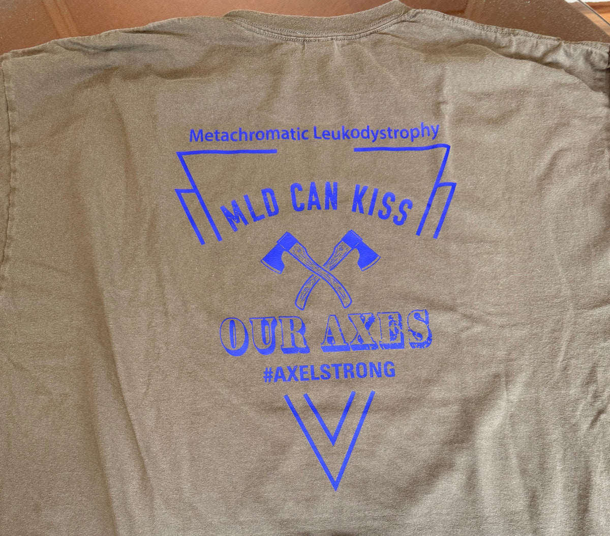 A dark gray crewneck t-shirt laid flat, showing the back side with a blue graphic print that reads 'Mild Can Kiss Our Axes' and 'Axelstrong'. 