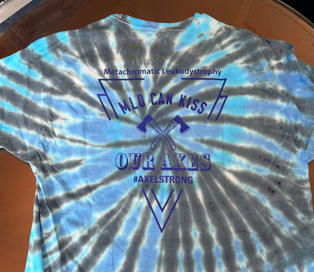 A blue and gray tie-dye t-shirt with a custom graphic print in dark blue on the front. The graphic features crossed axes and the text 'MLD CAN KISS OUR AXES #AXELSTRONG'.